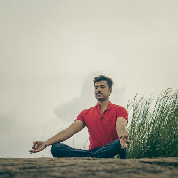 Person meditating in a beautiful natural setting, representing mental peace and clarity.